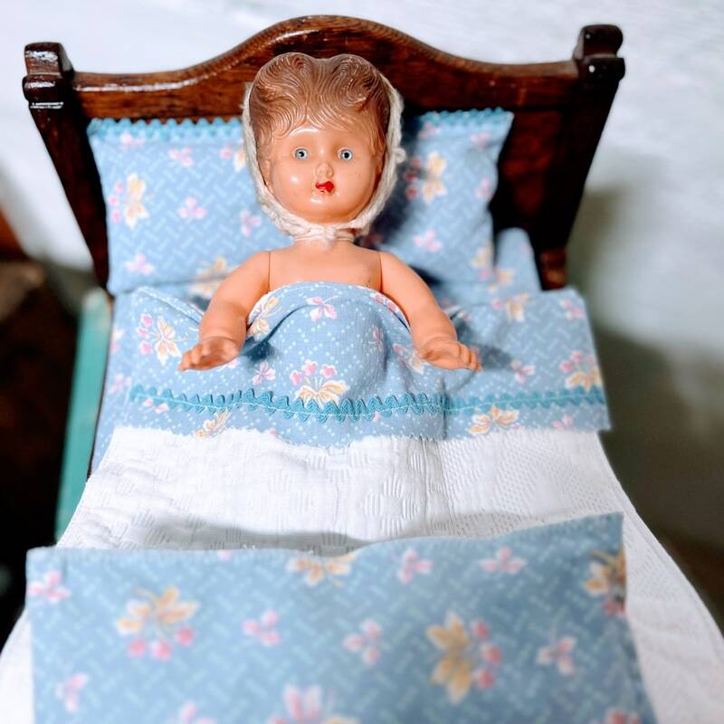 Old doll's bed in varnished wood