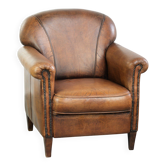 Comfortable characterful sheepskin armchair finished with decorative nails