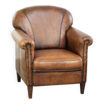 Comfortable characterful sheepskin armchair finished with decorative nails