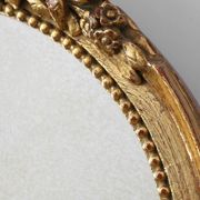 Oval giltwood mirror with rococo-style floral crest, mid-20th century