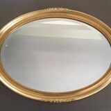 Beveled oval mirror with carved gilded wood frame