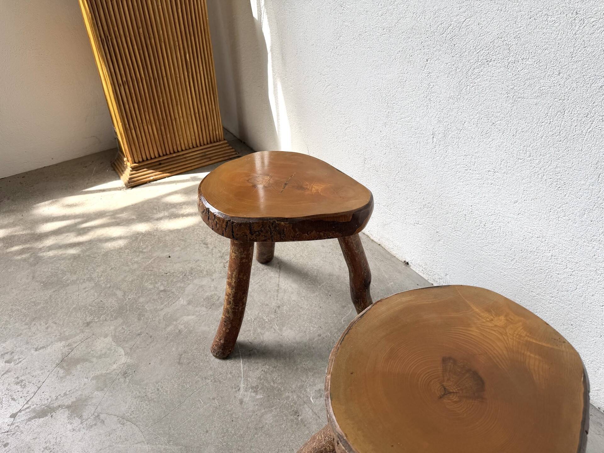 Set of three rustic solid wood tripod stools.