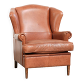Fauteuil anglais à oreilles de couleur cognac clair en cuir de vache.