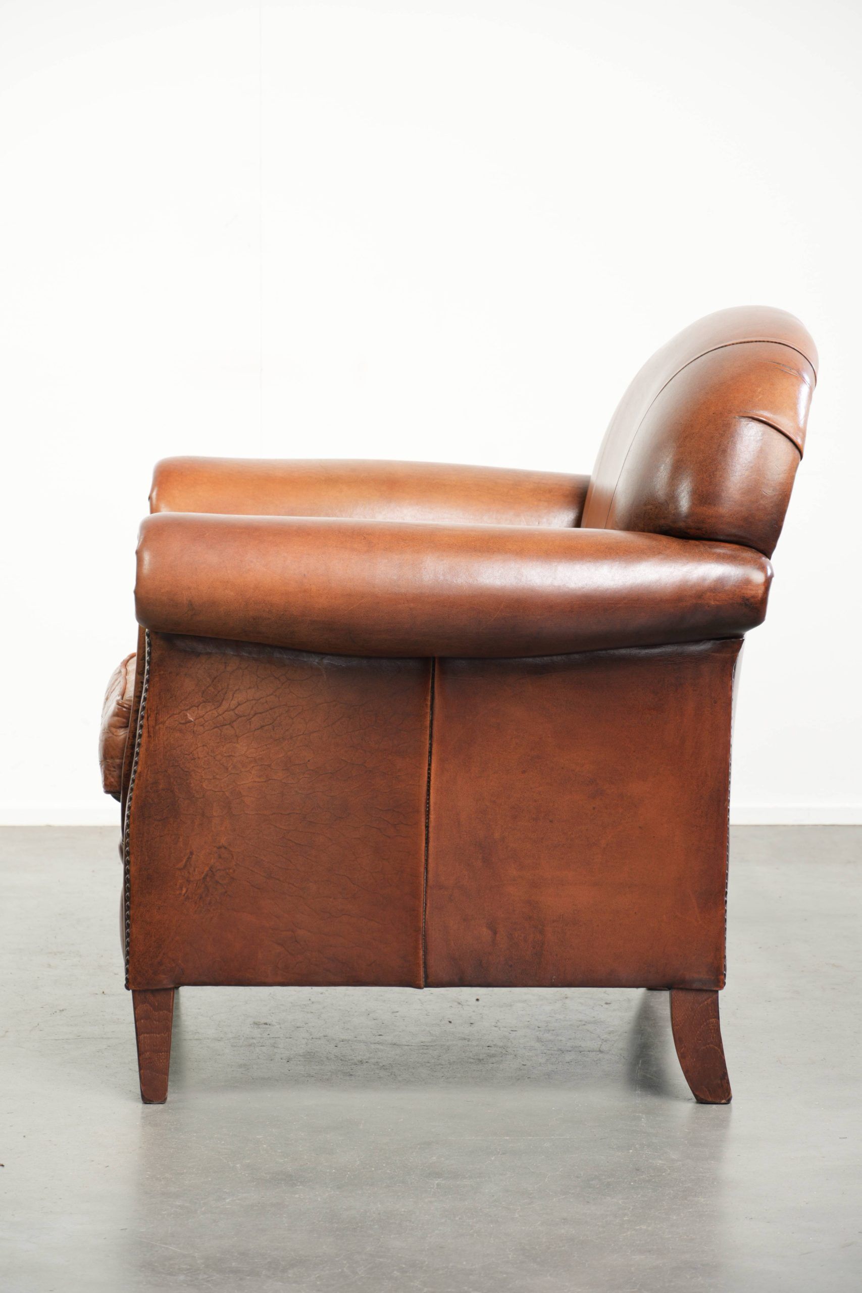 Sheepskin armchair with comfortable seat and finished with decorative nails
