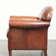 Sheepskin armchair with comfortable seat and finished with decorative nails