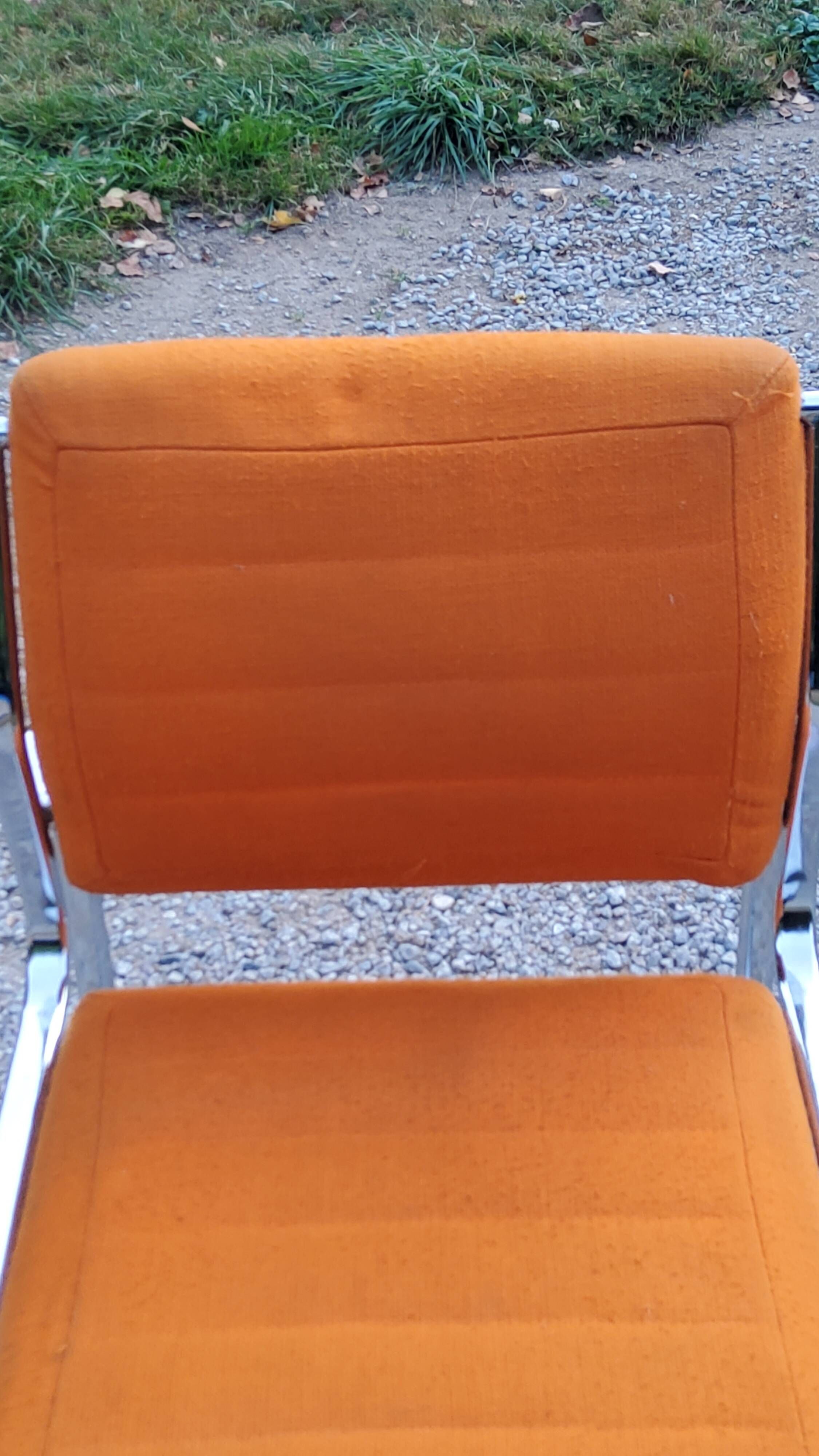 Pair of designer armchairs in orange fabrics and chrome tubes from the 70s