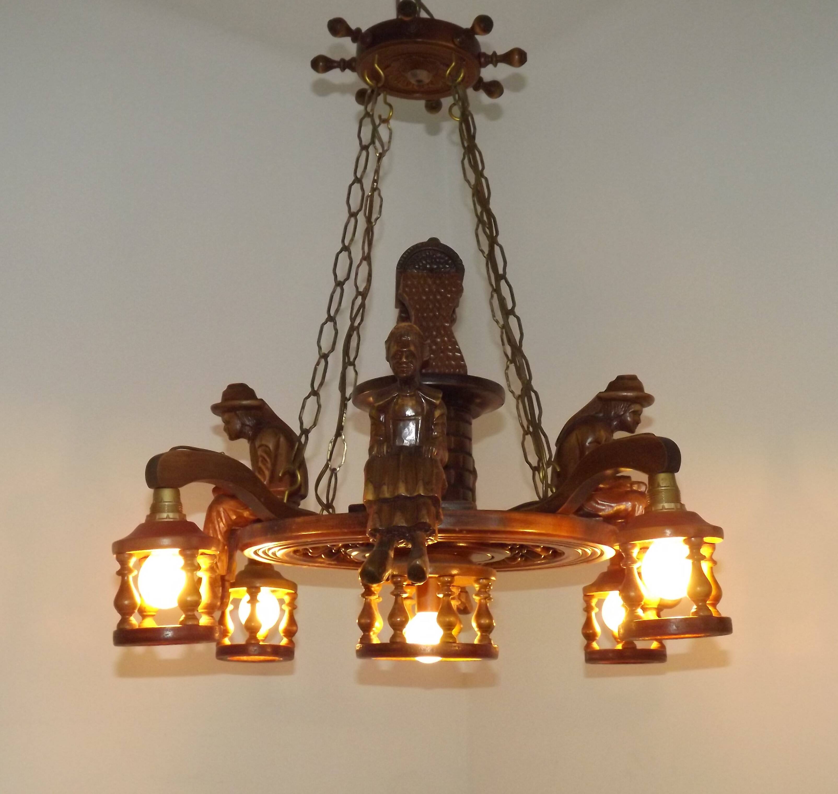 French vintage Breton chandelier with hand-carved figures, well, and lantern lights.