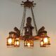 French vintage Breton chandelier with hand-carved figures, well, and lantern lights.