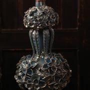 Une paire de lampes bleu clair iridescentes, avec un design de buisson floral.