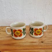 A pair of vintage Weidmann cups with an orange flower motif from the 1970s.