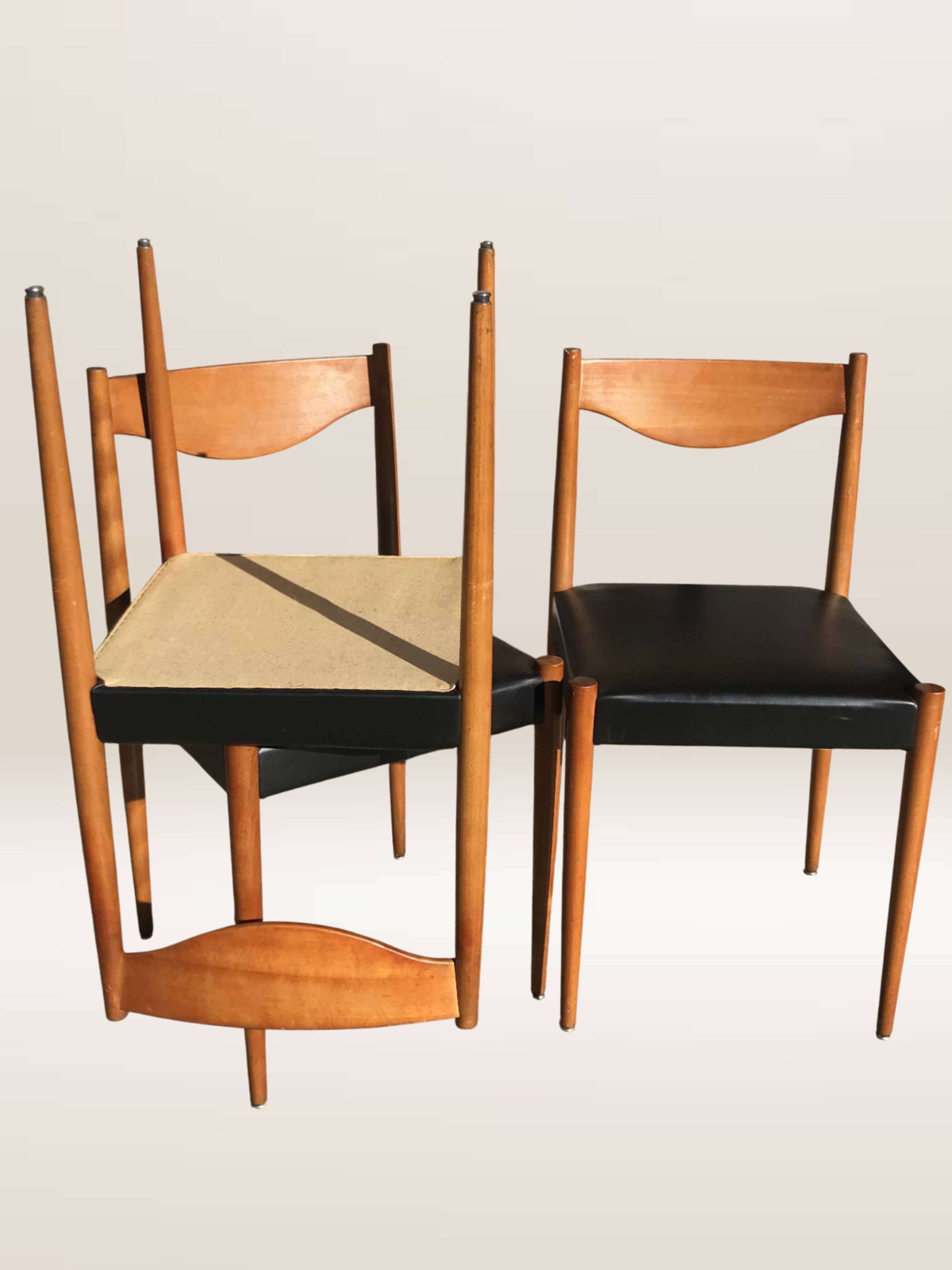Set of 6 modernist chairs with black faux leather seats.