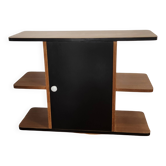 Compact bar cabinet with a pivoting door in black wood.