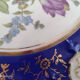 Plat rond creux en porcelaine allemande bleu nuit et motifs floraux polychromes et dorés