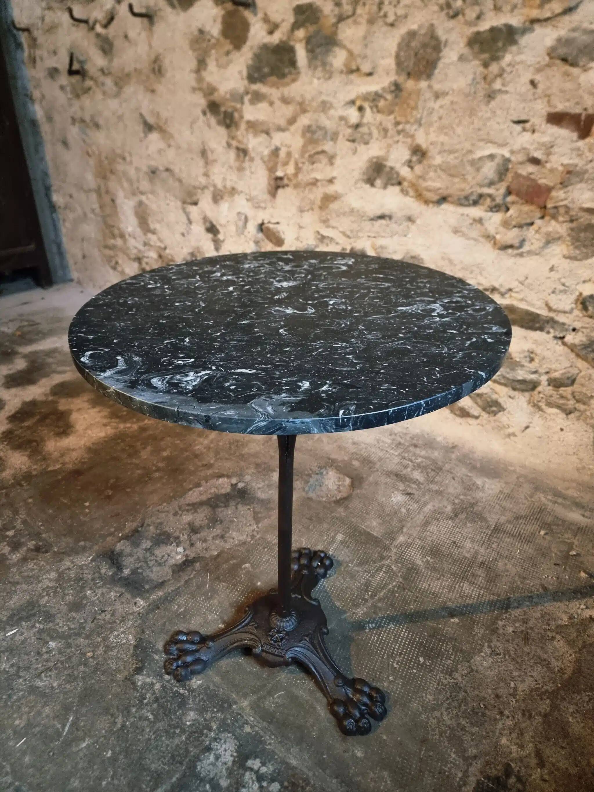 Old French bistro table with a marble top and a cast iron base.