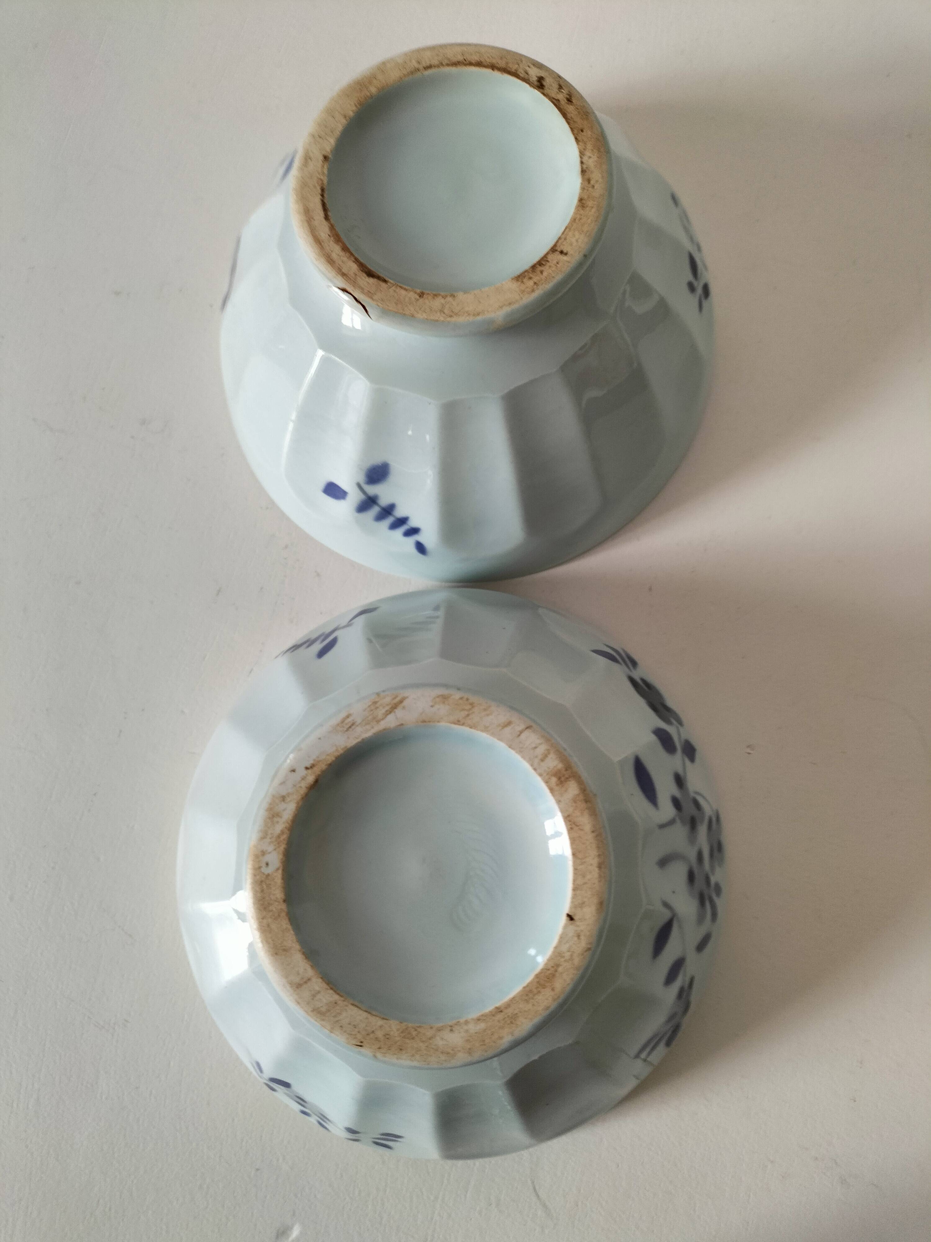 Two vintage farm bowls on a pale blue pedestal with floral decoration.