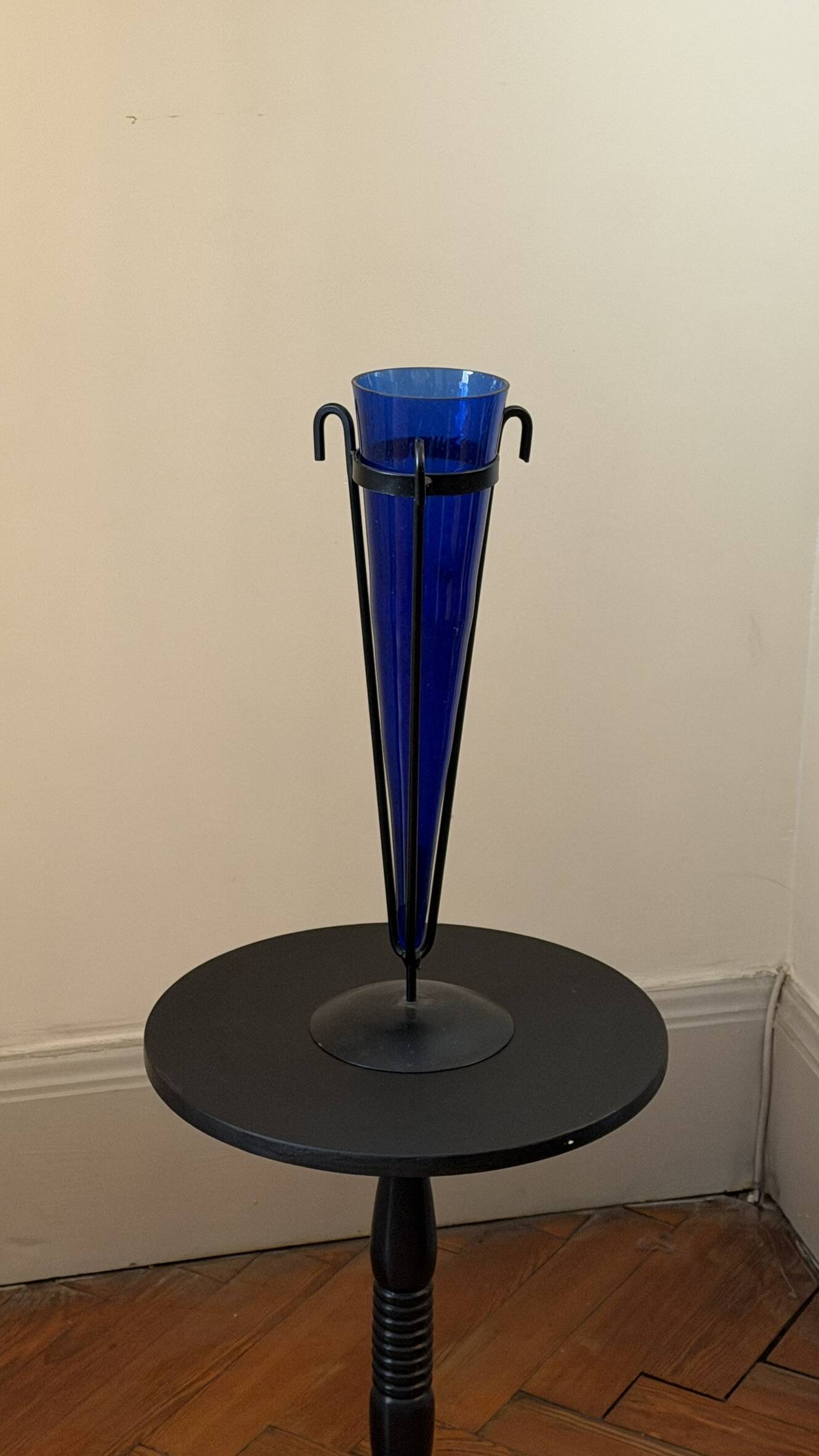 Cobalt blue vase on a metal structure.