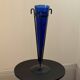 Cobalt blue vase on a metal structure.