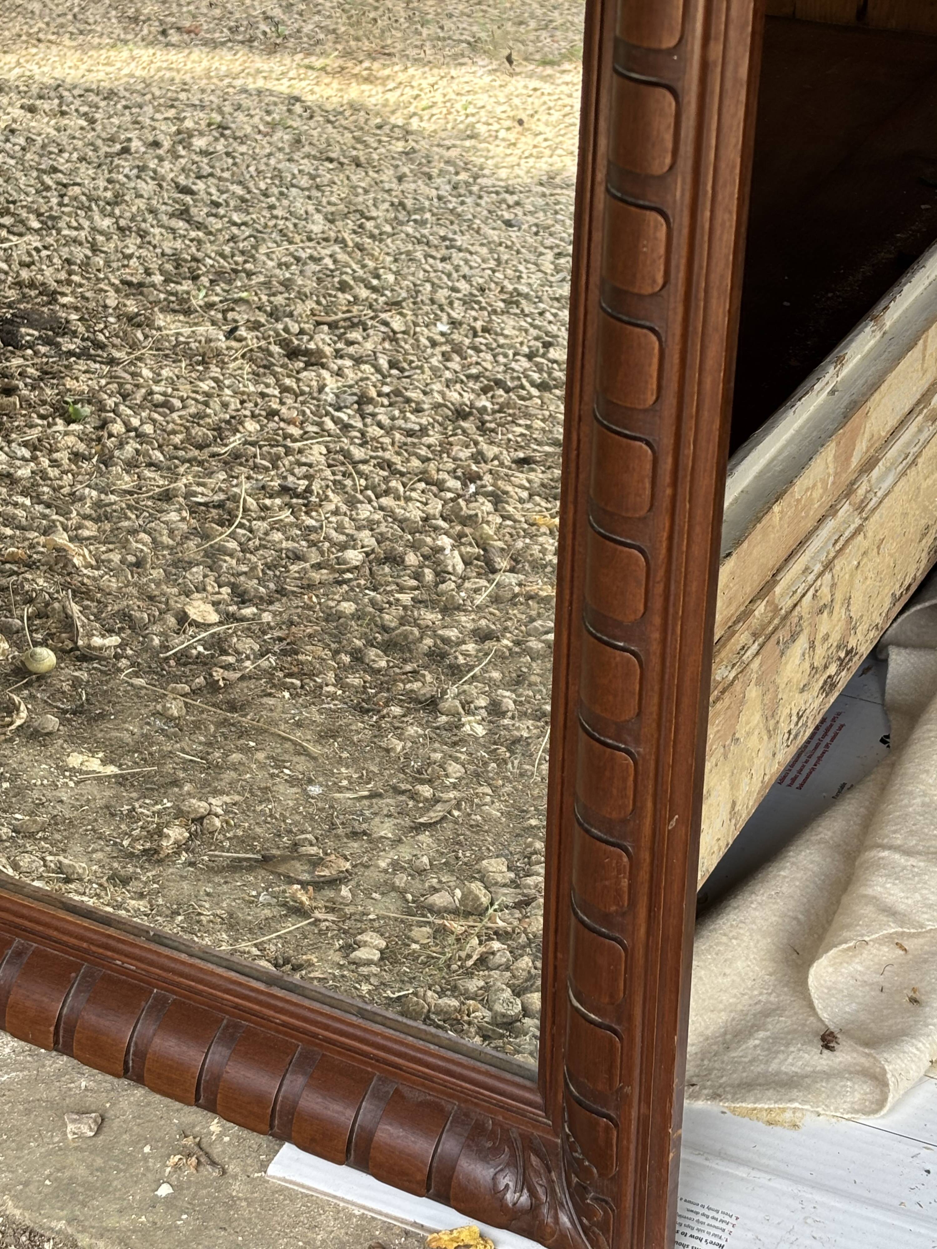 Large wall mirror with an elegant wooden frame.
