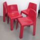 Four red fibreglass chairs from the 1970s.