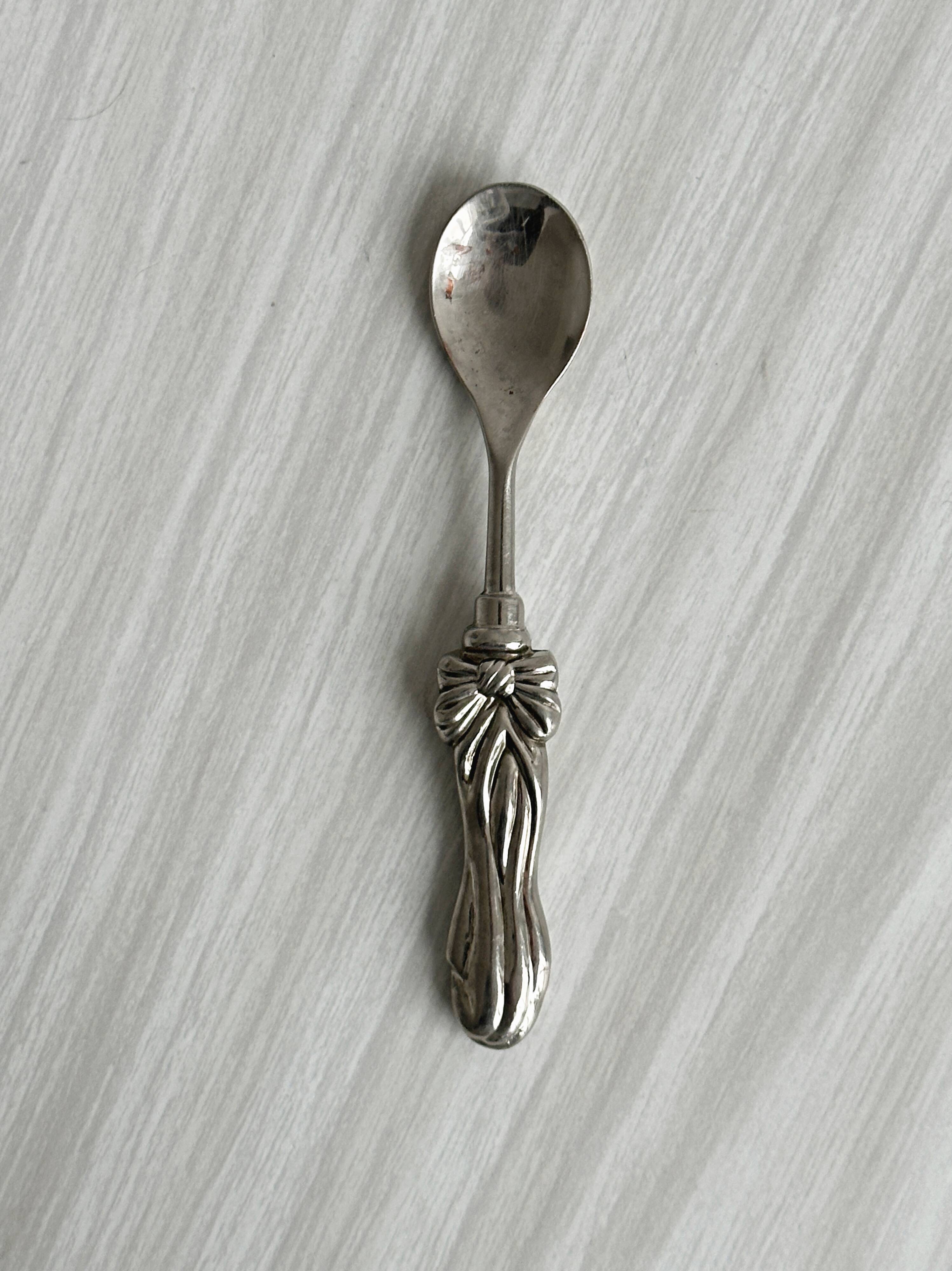 Antique small spoons with a metal bow design