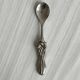 Antique small spoons with a metal bow design