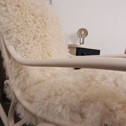 Antique Thonet rocking chair in ivory lacquered bent wood, with a white lamb fur seat.