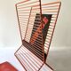 Wire metal magazine rack with triangular compartment, 1950s.