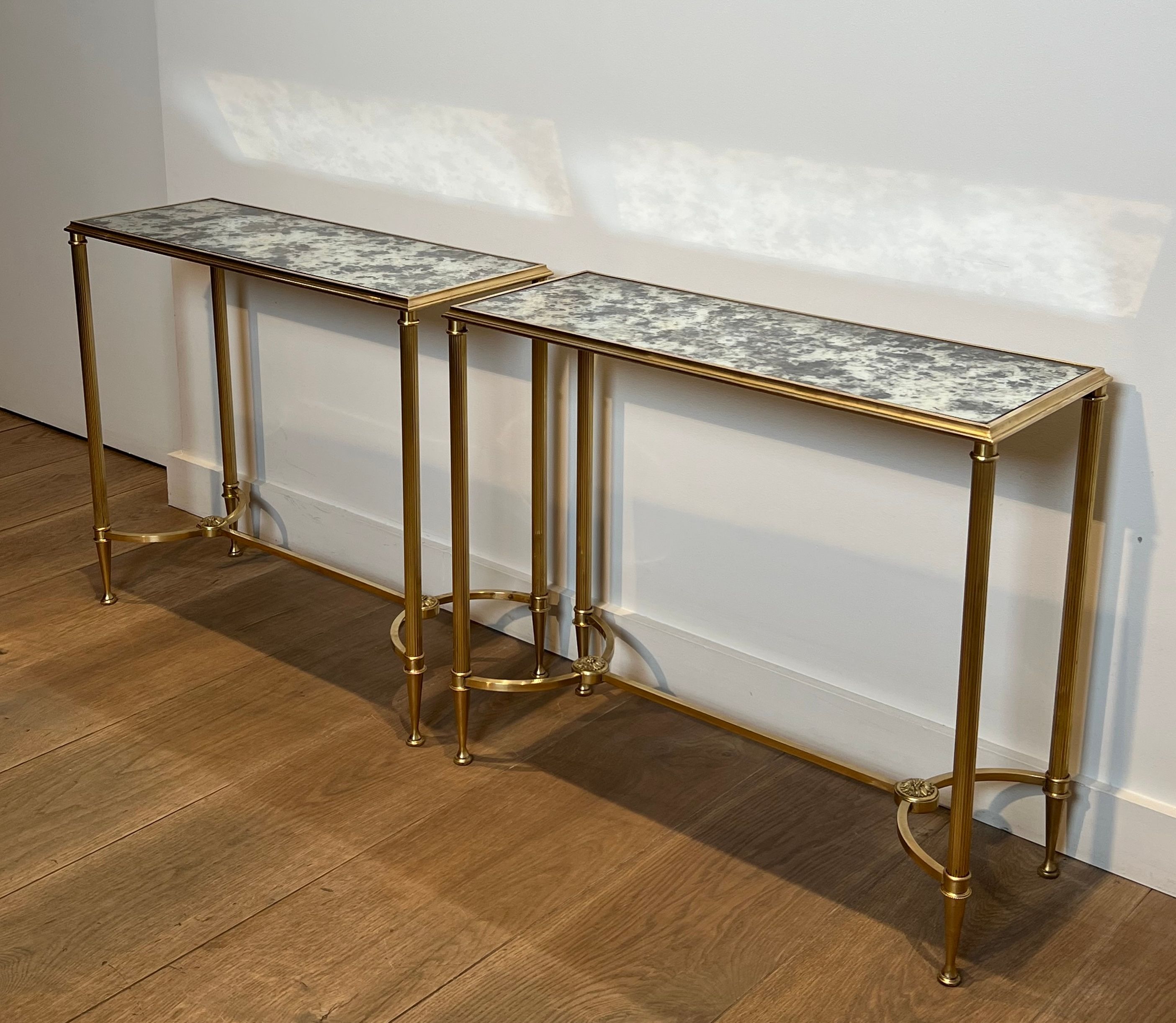 Pair of brass and antique mirror side tables from the Baguès house.