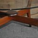 Mid-century coffee table in brown teak with a floating tempered glass top.