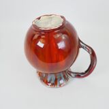 Large red and blue glazed ceramic pitcher signed Delène under the base