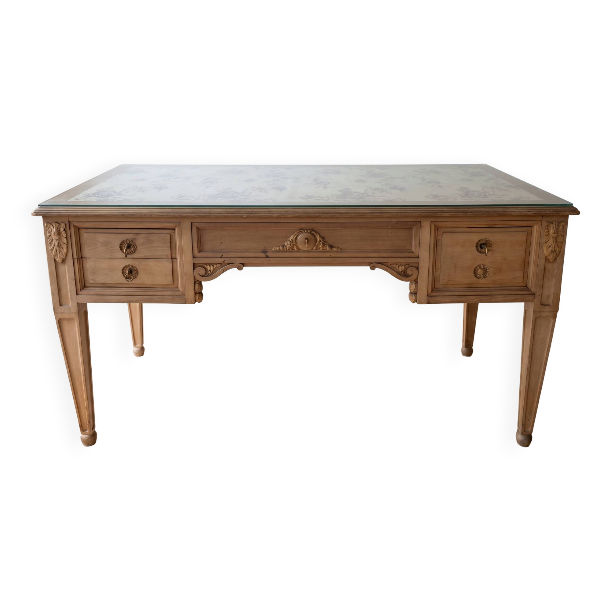 Solid wood desk with glass top and sculptures.