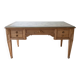 Solid wood desk with glass top and sculptures.