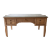 Solid wood desk with glass top and sculptures.