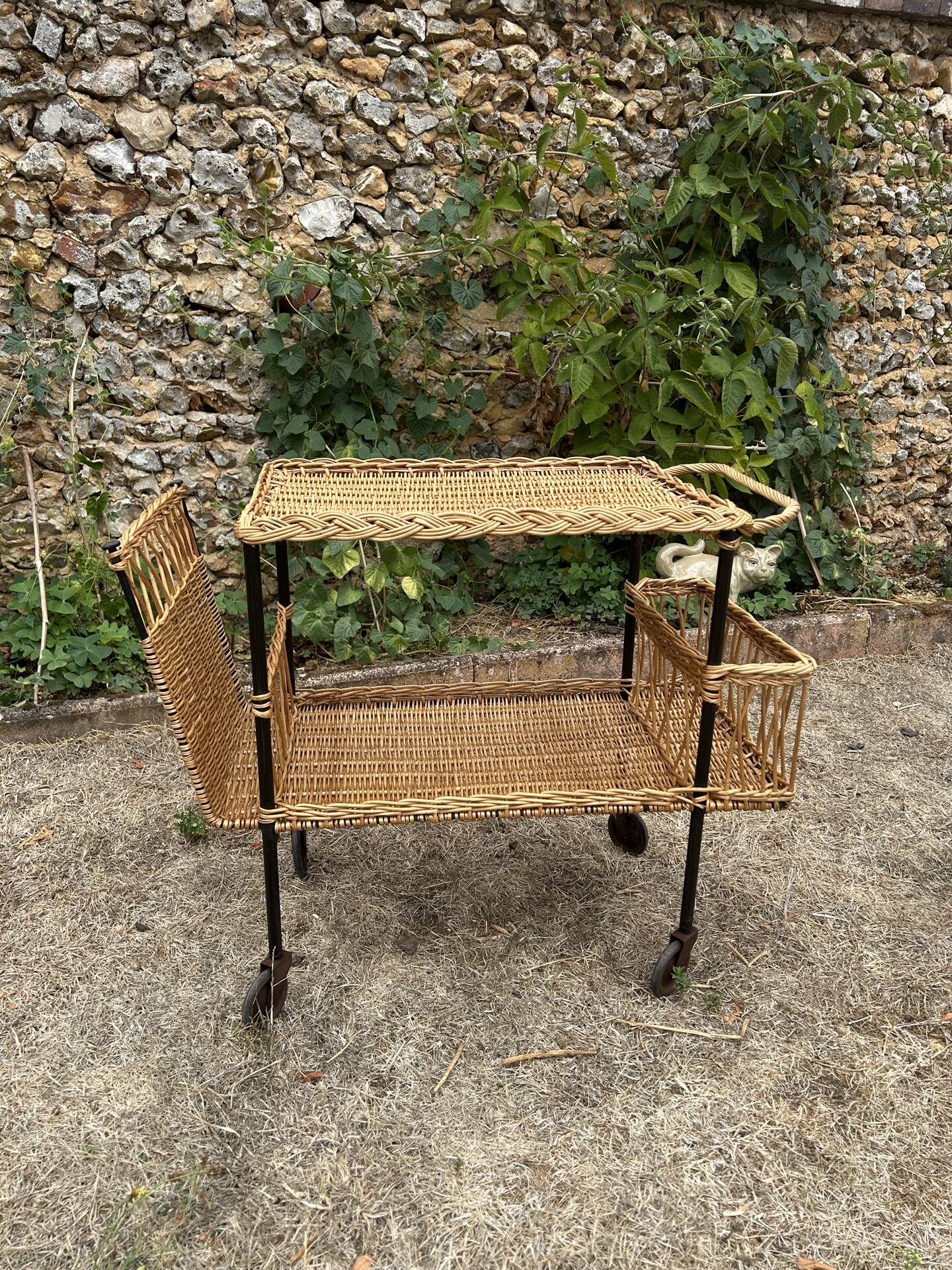 Vintage 1950s rolling dessert trolley in wicker and black tubing.