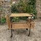 Vintage 1950s rolling dessert trolley in wicker and black tubing.
