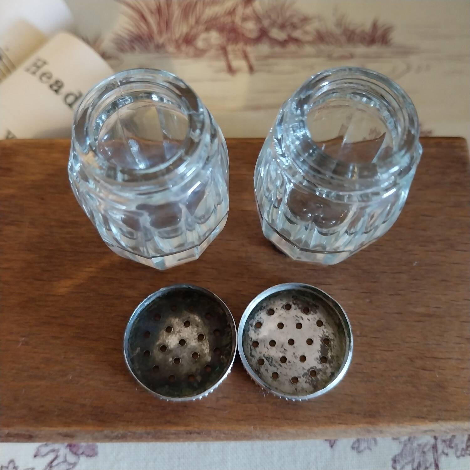 Antique salt and pepper shakers in crystal and silver metal.