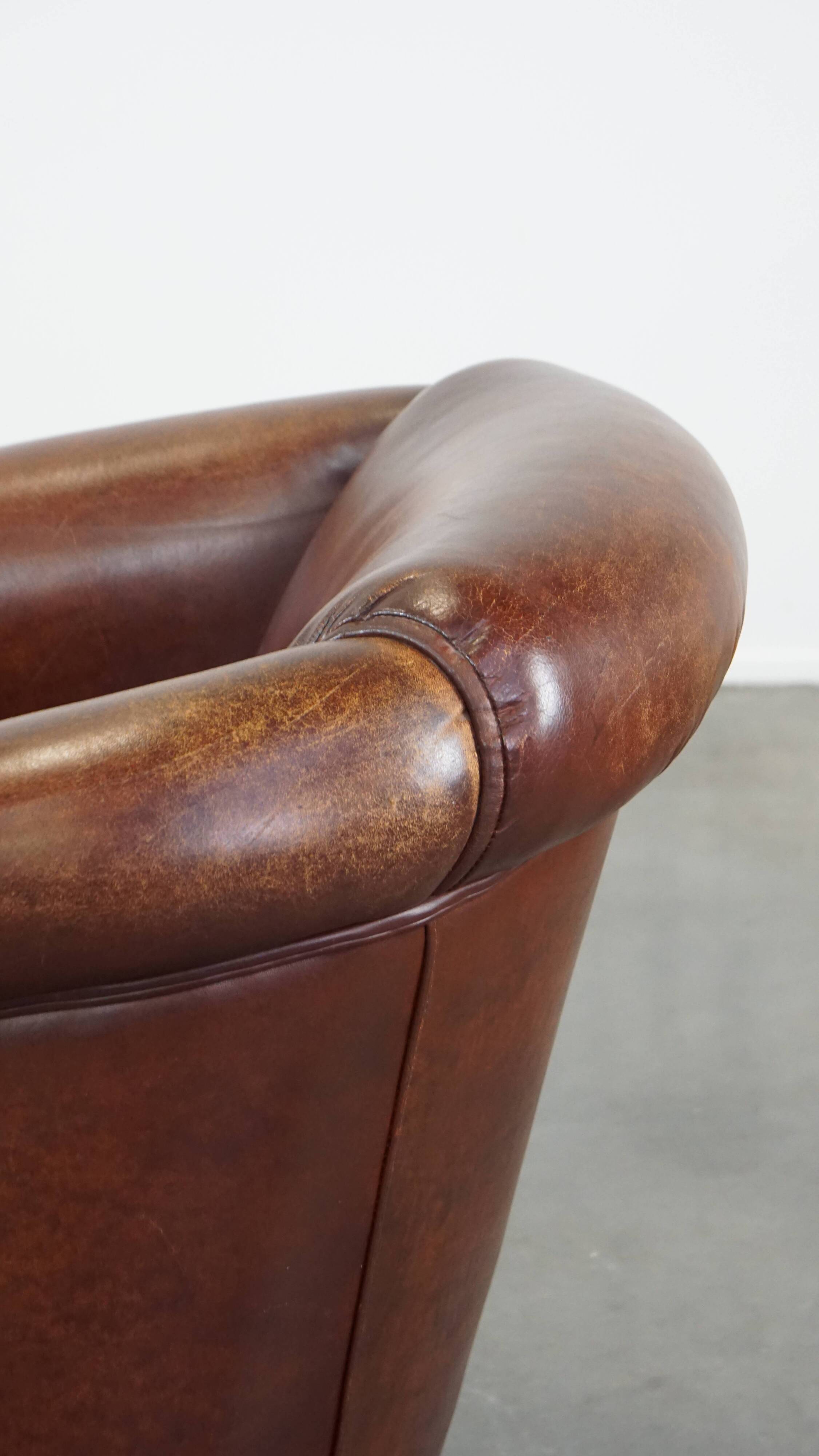 Sheepskin club armchair, correct finishing with decorative nails