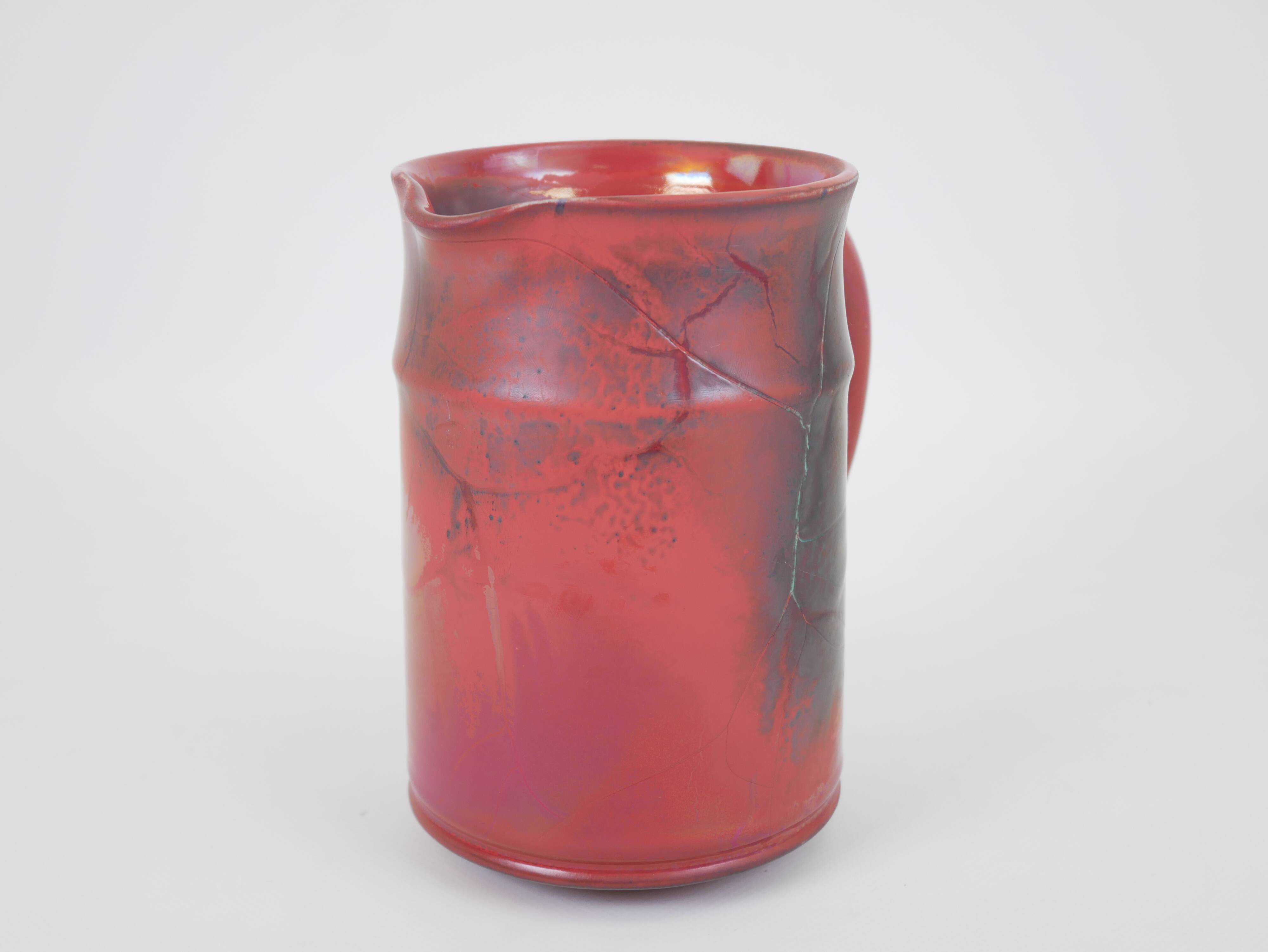 Red glazed ceramic jug with relief