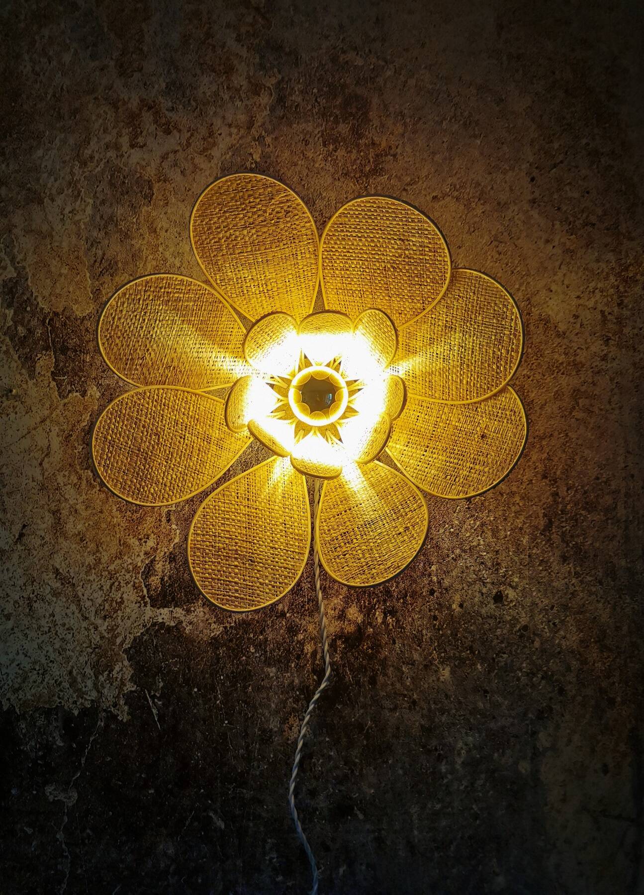 Flower wall light made of rattan and raffia petals