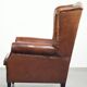 Sheepskin wingback armchair in a warm cognac colour with refined nailhead trim