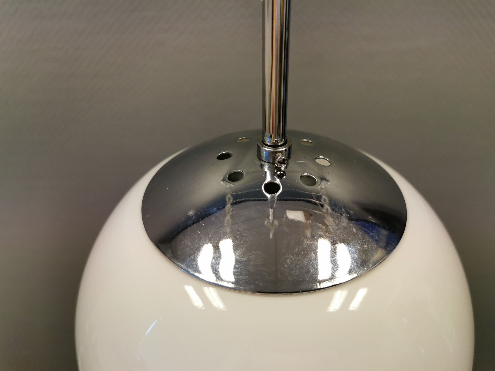 White hanging lamp with metal suspension, made with ball round opal glass shade.