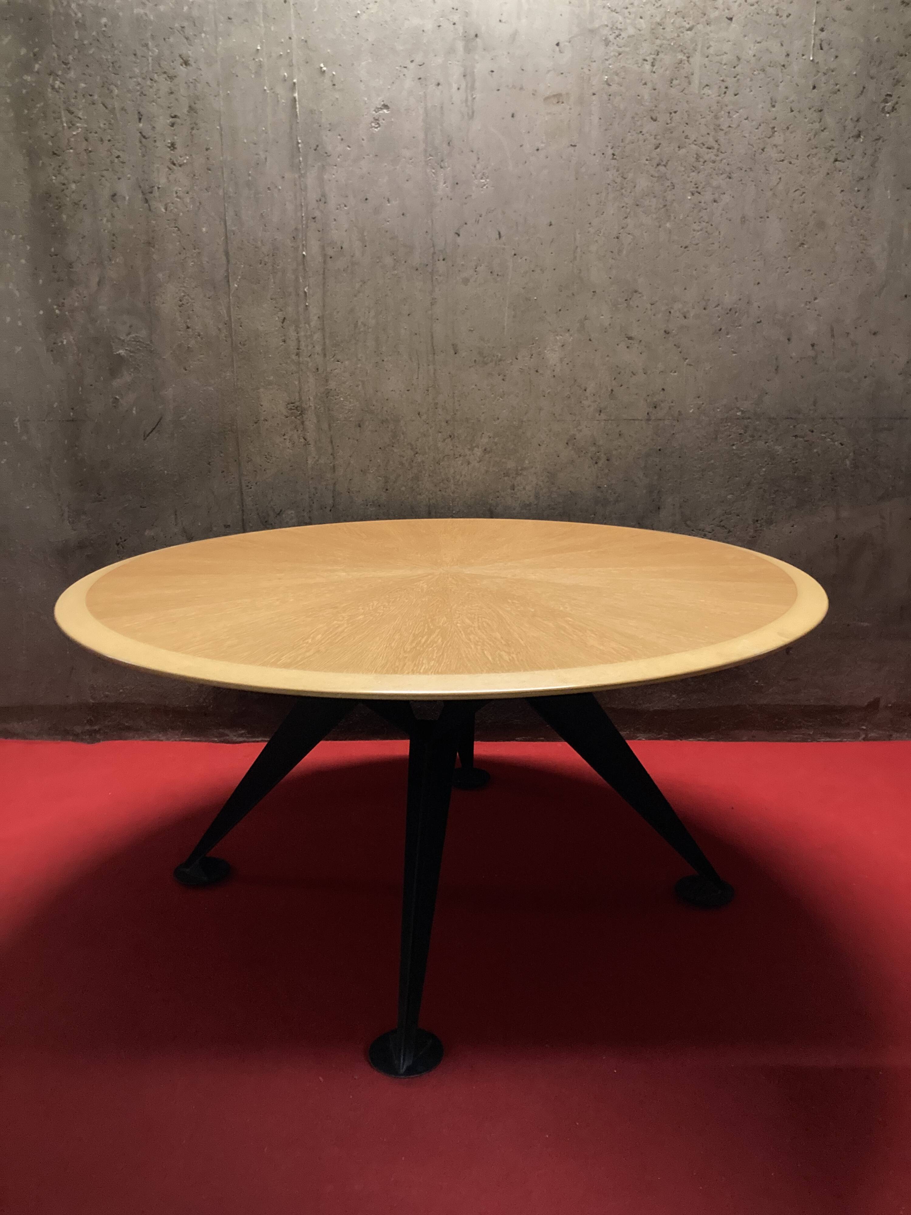 Round wooden and metal quadripod dining table