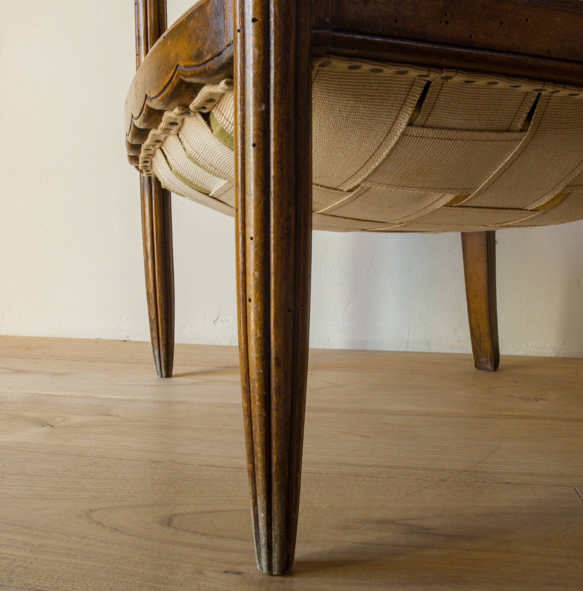 Antique armchair in solid wood and patinated brown leather, early 20th century.
