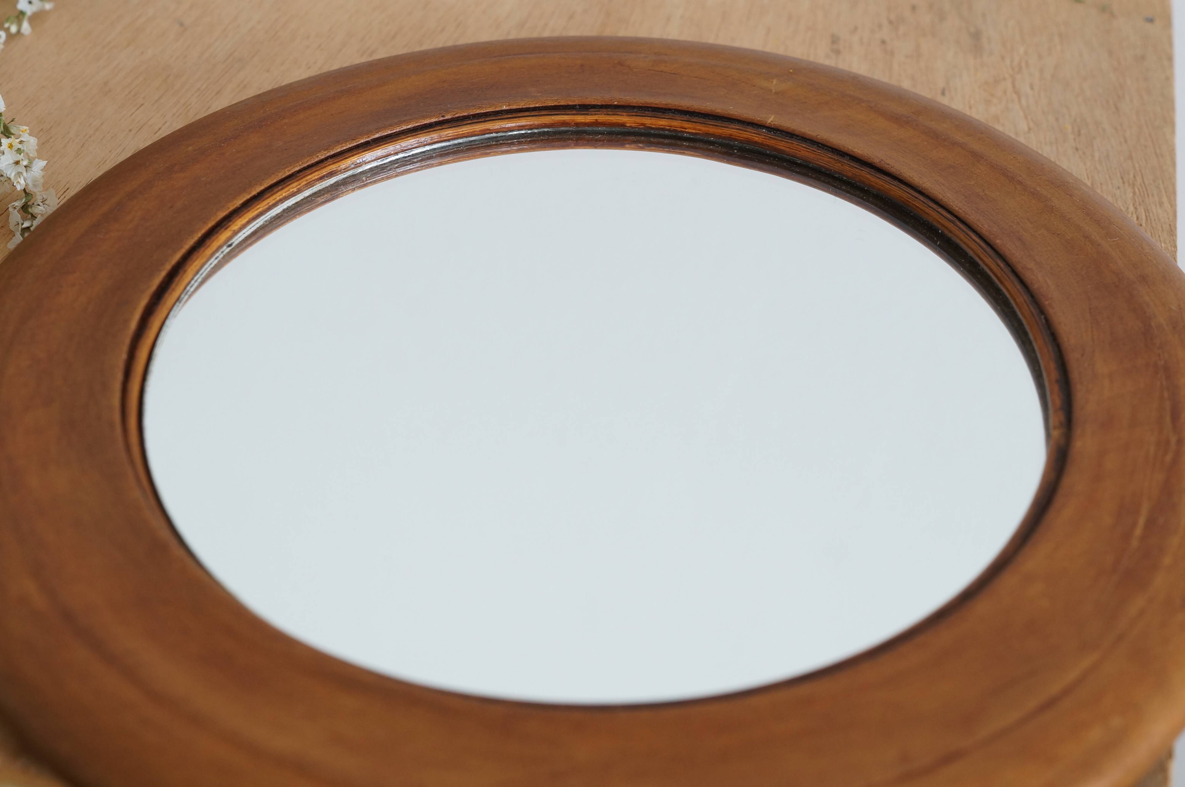 Antique round mirror with turned wooden frame