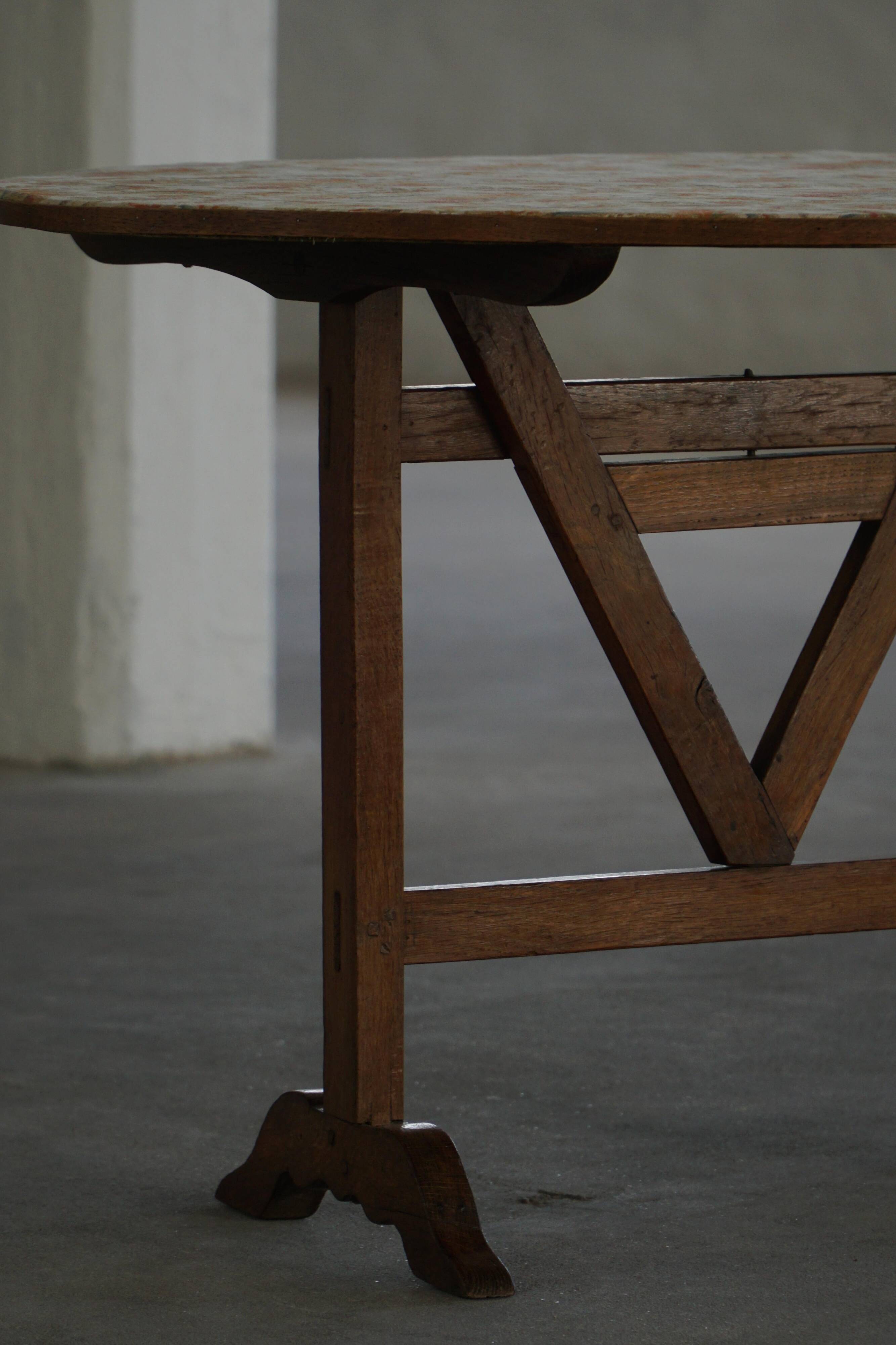 19th-century French round wine table with an adjustable top and floral textile surface.