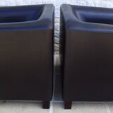 2 club armchairs with a chocolate faux leather seat and backrest and wooden legs.