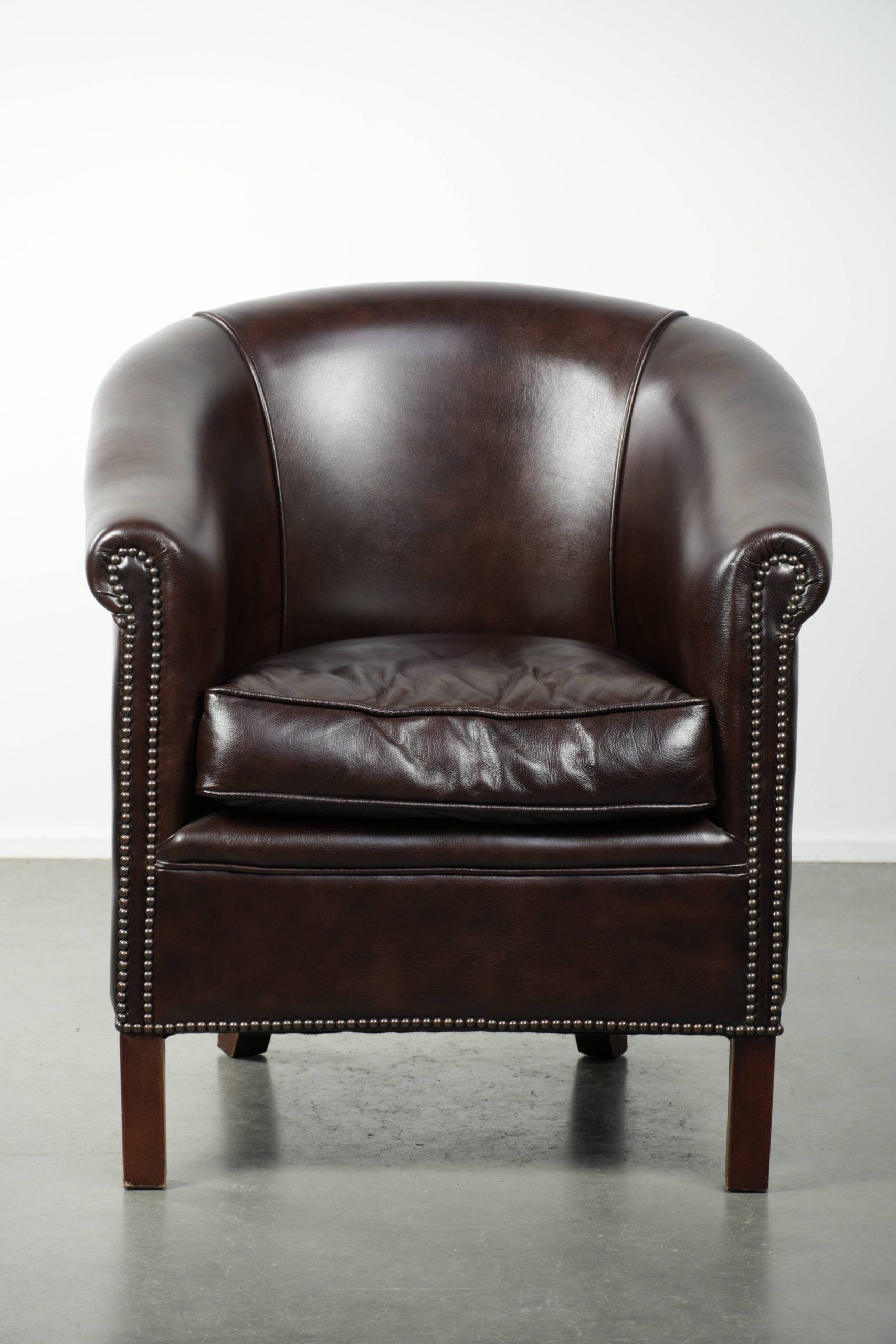 Dark cow leather club armchair with a stylish design in English style