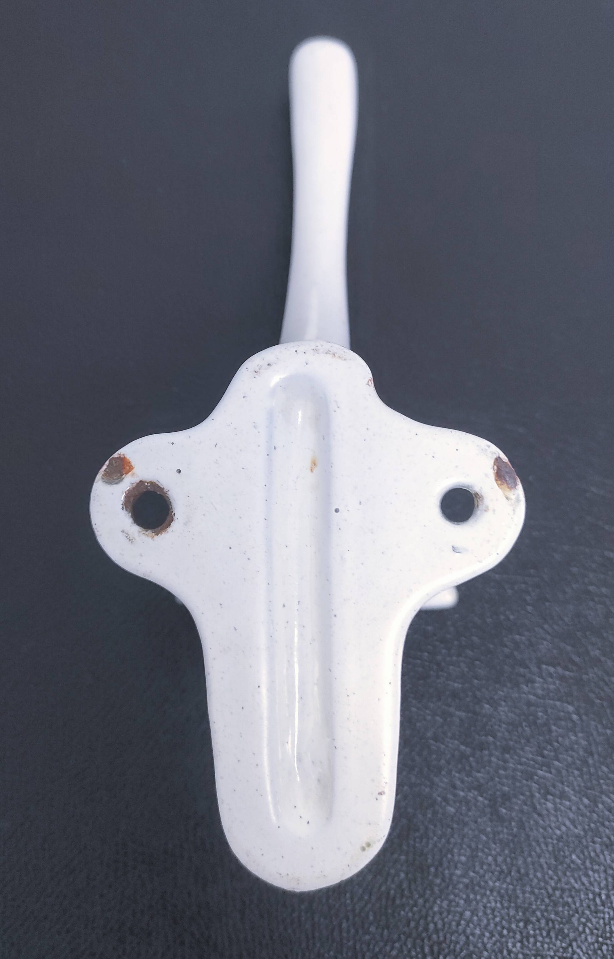 Three enameled cast iron coat hooks and vintage patina metal