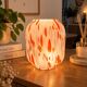 Vintage orange and white glass lamp with golden accents.