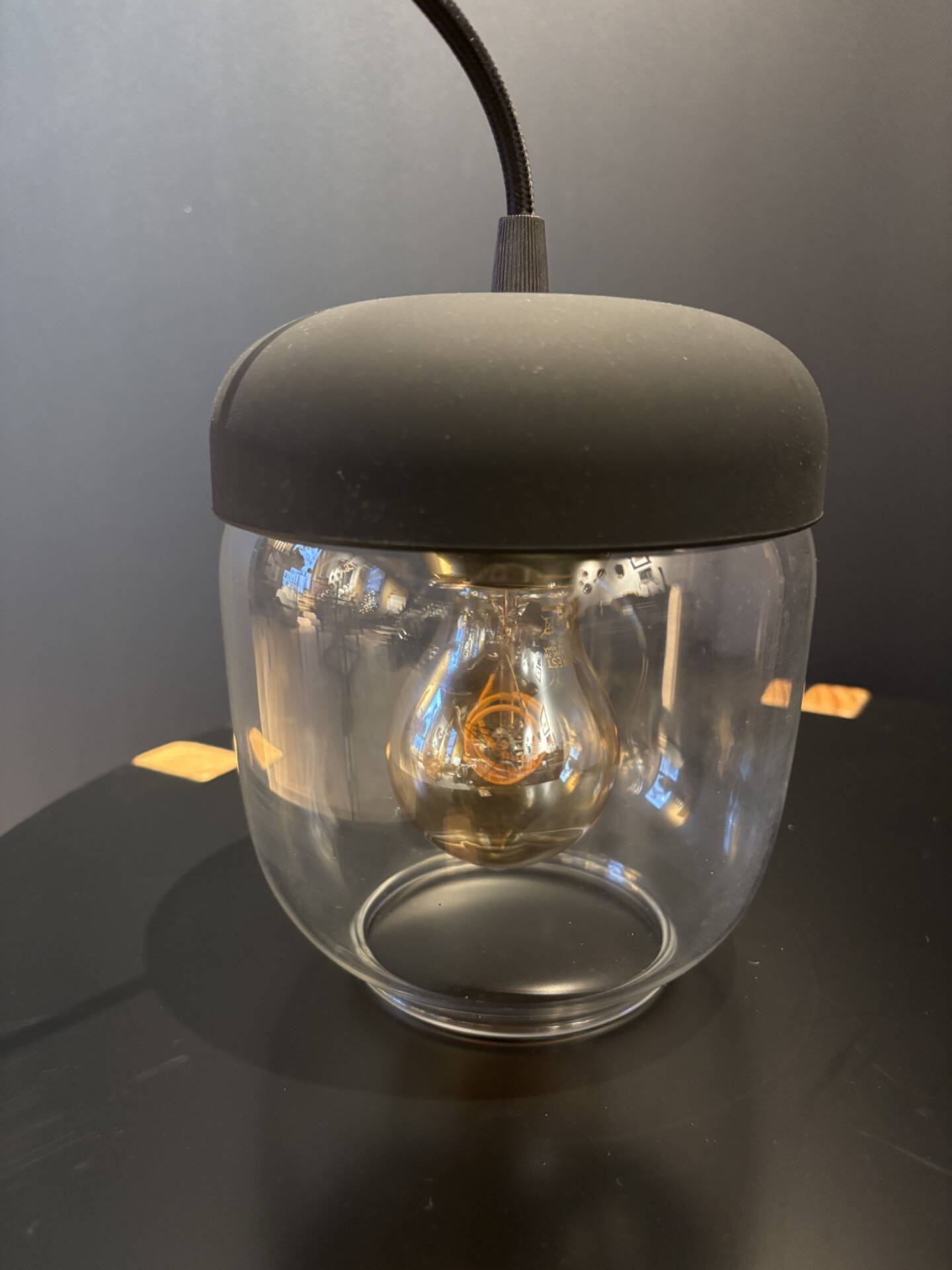 Portable lamp with transparent glass and black plastic.